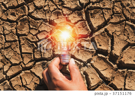 hand holding light bulb on soil arid.concept power 37151176