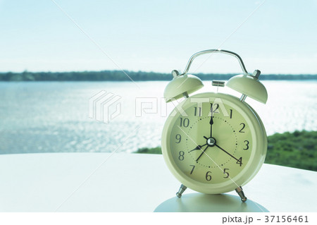 Alarm clock on white table with river and nature 37156461