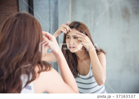 Woman squeeze her pimple in bathroom Woman squeeze her pimple in bathroom 37163537