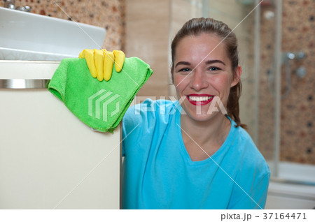 Charming positive woman doing cleaning at home Charming positive woman doing cleaning at home 37164471