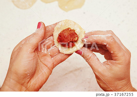 cook puts minced meat on dough 37167255