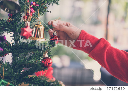 woman holding xmas ornament. girl decorate Christmas tree in a house. holiday celebration. 37171650