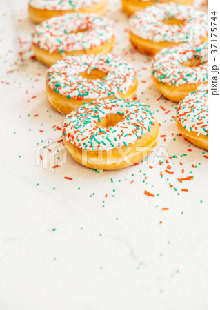 Donuts with white chocolate cream and sprinkles sugar Donuts with white chocolate cream and sprinkles sugar 37175744