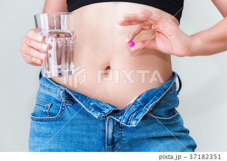 Portrait of young woman showing diet pills 37182351