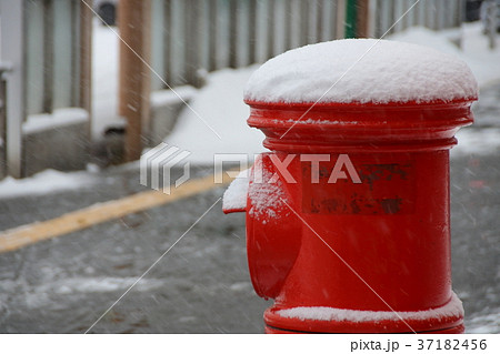 雪を被った郵便ポスト 丸型ポスト の写真素材