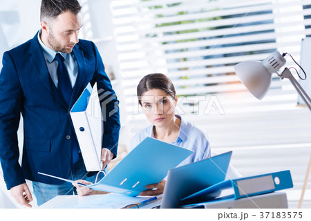 Strict woman holding a folder and looking 37183575