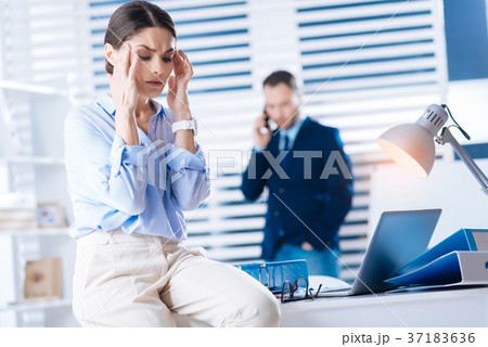 Beautiful woman sitting on the table with closed 37183636