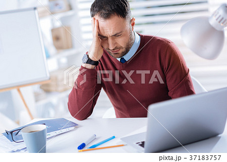 Young tired man feeling unwell while being at his Young tired man feeling unwell while being at his 37183757