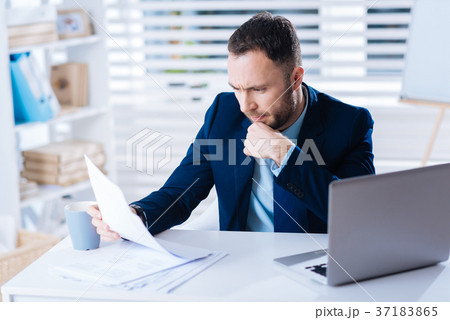 Busy young manager looking concentrated while 37183865