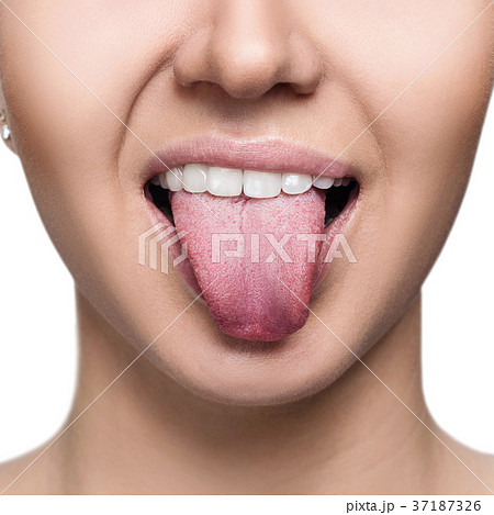 Close-up portrait of woman shows tongue grimace. 37187326