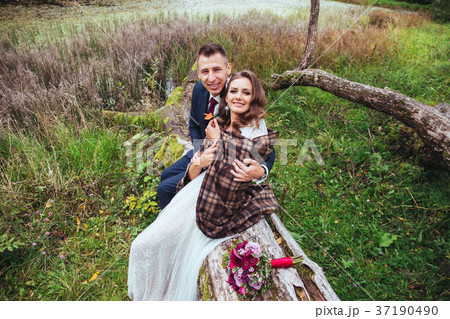 wedding in autumn .Bride and groom sitting in park 37190490