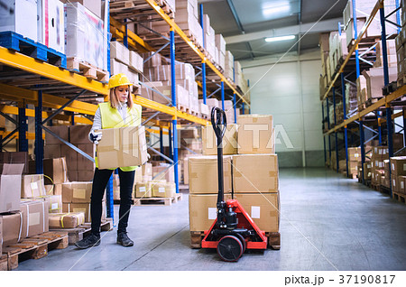 Female warehouse worker loading boxes. 37190817