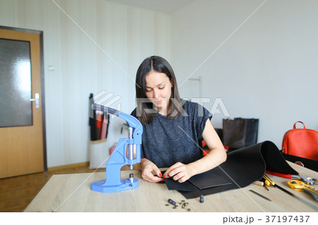 girl preparing leather for making purse. 37197437