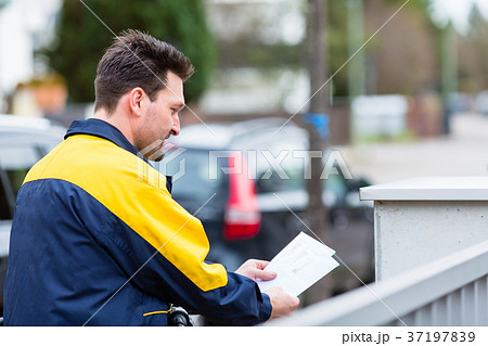 Postman delivering letters to mailbox of recipient Postman delivering letters to mailbox of recipient 37197839