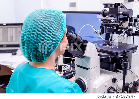 Embryologist adding sperm to egg in laboratory  37197847