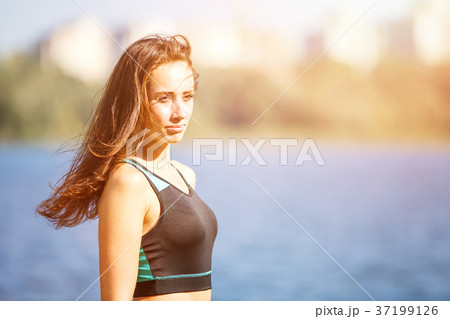 Portrait of young sporty woman resting after jog Portrait of young sporty woman resting after jog 37199126