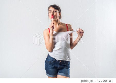 Young brunette model with lollipop posing studio 37200181