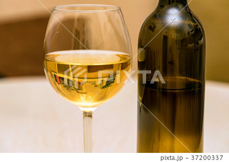 Glass of white wine and bottle 37200337