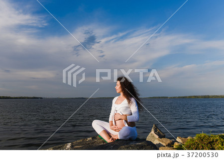 Meditating pregnant woman in lotus position. 37200530