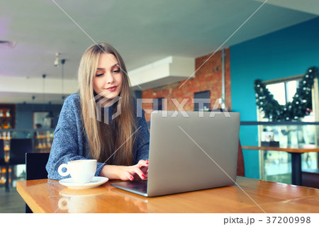 Woman working on laptop in a cafe. Young woman 37200998