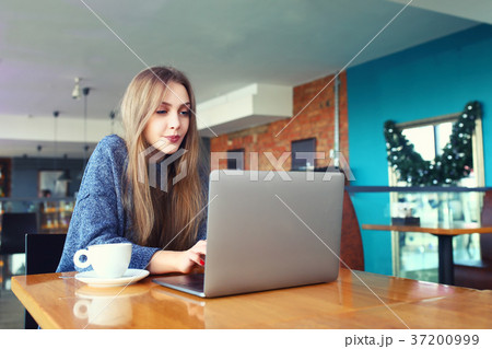 Woman working on laptop in a cafe. Young woman 37200999