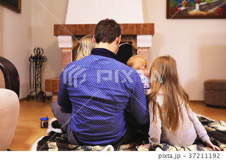 family warmed by the fireplace sitting on the family warmed by the fireplace sitting on the 37211192