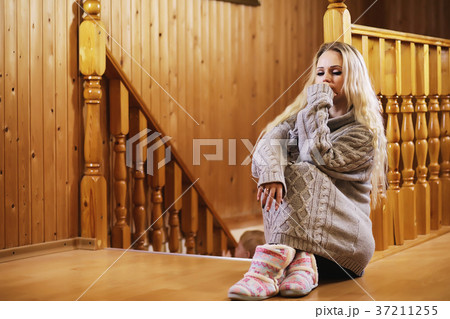 A young girl sits on a ladder in a sweater 37211255