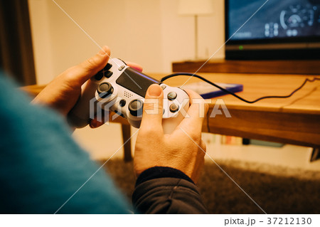 部屋でゲームをする男性の手元 37212130