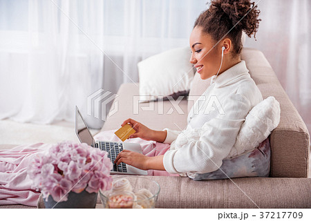 Joyful girl purchasing through internet on laptop 37217709