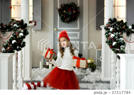 Happy little girl holding a lot of boxes with 37217784