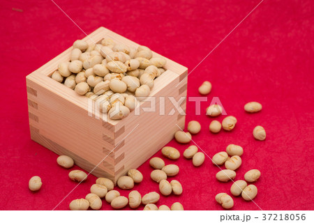 枡から溢れる節分の福豆 紅色の和紙の背景　d-2  左寄せ やや上から 37218056