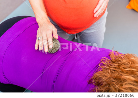 Pregnant young women getting backrub with spiky Pregnant young women getting backrub with spiky 37218066