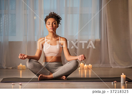 Relaxed young woman doing yoga exercise for 37218325
