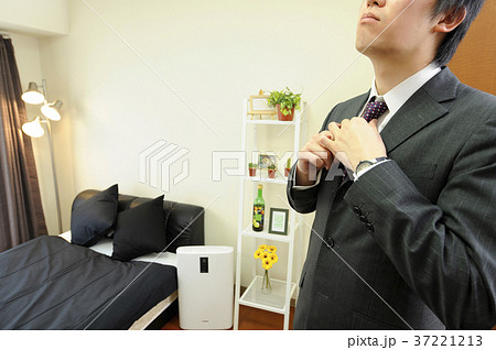 部屋でネクタイをしめるサラリーマン 37221213