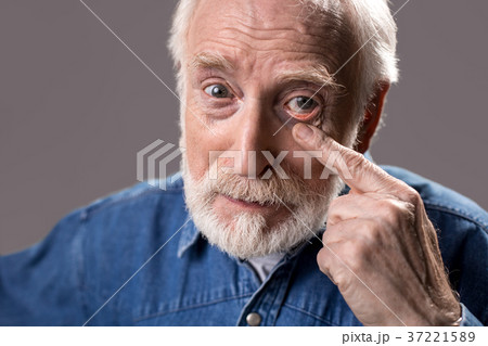 Concentrated old man indicating to his optic 37221589