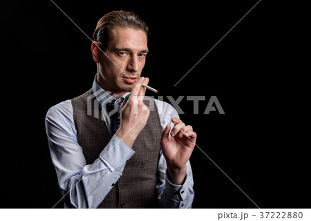 Trendy young businessman is holding cigarette Trendy young businessman is holding cigarette 37222880