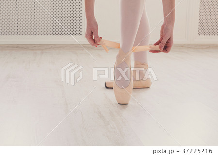 Ballerina puts on pointe ballet shoes, graceful Ballerina puts on pointe ballet shoes, graceful 37225216