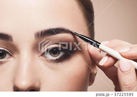 Make-up artist apply eyebrow shadow with brush 37225595