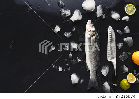 Fresh sea bass with ice at black background Fresh sea bass with ice at black background 37225974