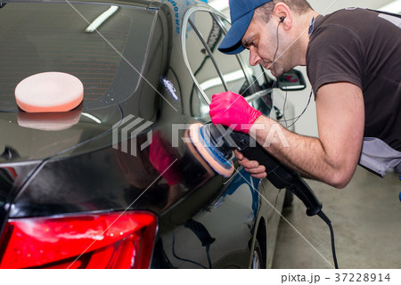 A man polishes a black car A man polishes a black car 37228914