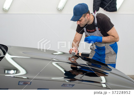 A man polishes a black car 37228952