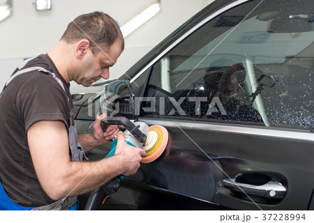 A man polishes a black car A man polishes a black car 37228994