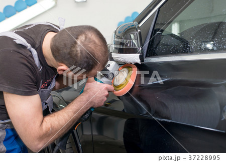 A man polishes a black car A man polishes a black car 37228995
