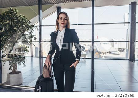 Beautiful airhostess standing in her uniform with Beautiful airhostess standing in her uniform with 37230569