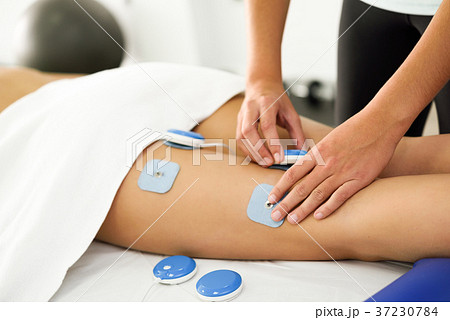 Physiotherapist applying electro stimulation 37230784