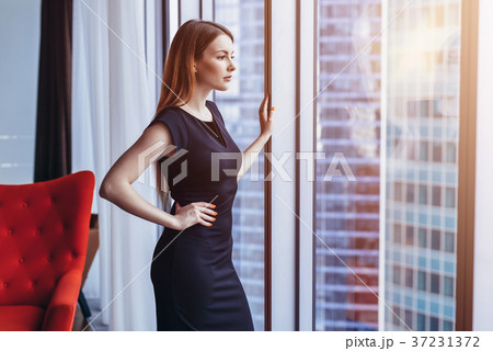 Well-off attractive woman thinking standing at the Well-off attractive woman thinking standing at the 37231372