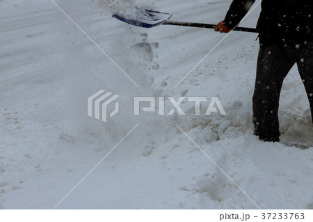 Man cleaning snow from a walkway with  37233763