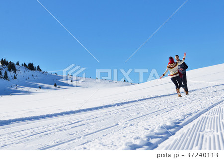 Couple having fun running down slope Couple having fun running down slope 37240113