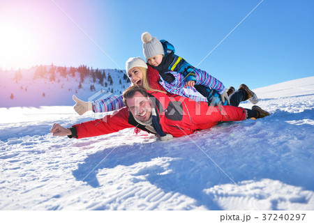 happy young family playing in fresh snow at happy young family playing in fresh snow at 37240297