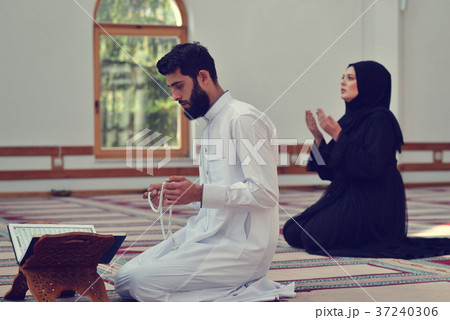 Muslim man and woman praying in mosque Muslim man and woman praying in mosque 37240306